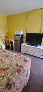 um quarto de hotel com uma cama e uma televisão de ecrã plano em Deluxe Inn Jasper em Jasper