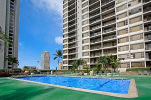 a swimming pool in front of a large building at Rec Deck Suite, 1 Bed Condo + Free Parking in Honolulu