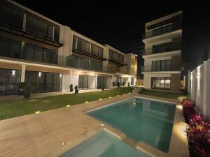 a house with a swimming pool in the yard at night at Suite Nueva en Salinas - Chipipe, en conjunto privado in Salinas