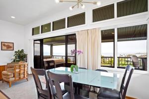 a dining room with a table and chairs and windows at K B M Resorts- KRV-1023 Spacious Luxury Villa with Sweeping Ocean Golf and Mountain views in Kaanapali
