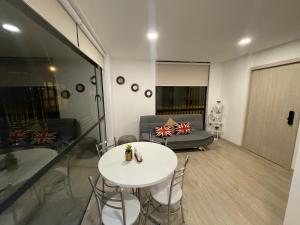sala de estar con mesa blanca y sofá en Suite Nueva en Salinas - Chipipe, en conjunto privado, en Salinas
