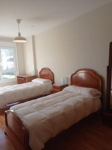 - une chambre avec 2 lits et une fenêtre dans l'établissement Apartamento Isidro Parga Pondal, à Laxe