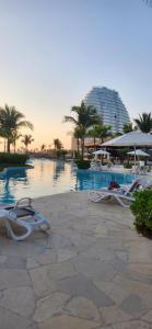 a group of lounge chairs next to a swimming pool at Hermoso departamento Acapulco in Acapulco