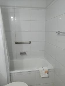 een witte badkamer met een bad en een toilet bij Nuevo Amanecer in Santiago