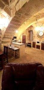 a living room with a couch and a kitchen at Il Mithna farmhouse with indoor heated jacuzzi pool in Għarb