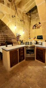 a kitchen with a stove top oven in a room at Il Mithna farmhouse with indoor heated jacuzzi pool in Għarb