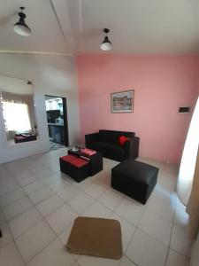 sala de estar con sofá negro y pared rosa en Hospedaje Kuruf en La Punta