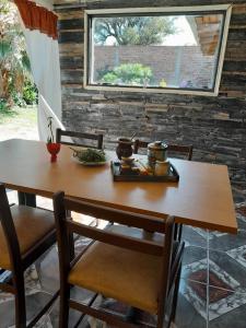 una mesa de madera con 2 sillas y una ventana en Hospedaje Kuruf en La Punta