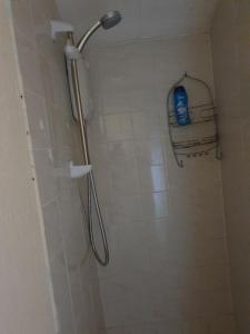 een douche met een douchekop in de badkamer bij Litherland Apartment in Litherland