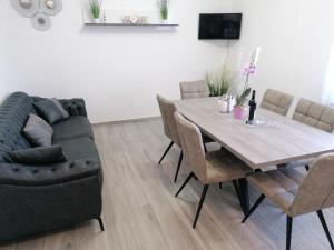 a dining room with a table and a couch at Apartments by the sea Arbanija, Ciovo - 11321 in Trogir