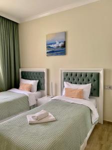 Dos camas en una habitación de hotel con toallas. en Guest House Botanical Paradise, en Mtsvane Kontskhi