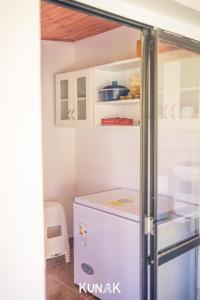 a refrigerator in a kitchen with white cabinets at kunak in Yala