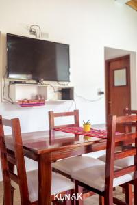 a wooden table with chairs and a television on a wall at kunak in Yala