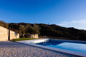 a swimming pool in a yard next to a mountain at Casa do Estended'Oiro in Seia