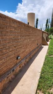 una pared de ladrillo con una acera al lado de un edificio en Cabañas Sixilera en Huacalera