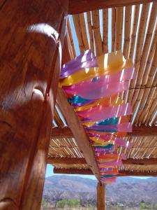 a colorful chandelier hanging from a wooden ceiling at Cabañas Sixilera in Huacalera