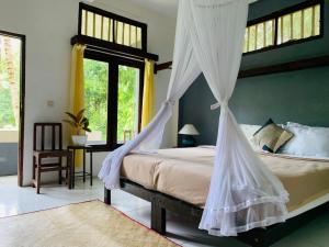 Schlafzimmer mit einem Bett mit Moskitonetz in der Unterkunft JOSEPH GUEST HOUSE in Kelimutu