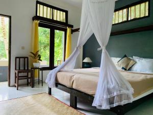 a bedroom with a bed with a mosquito net at JOSEPH GUEST HOUSE in Kelimutu