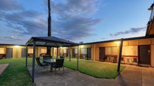 eine Terrasse mit einem Tisch und Stühlen unter einem Zelt in der Unterkunft Cootamundra Gardens Motel in Cootamundra