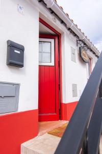 a red door on the side of a building at Casa da T´Idalete in Ourique