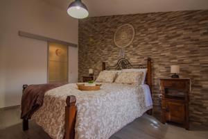 1 dormitorio con cama y pared de ladrillo en Casa da T´Idalete, en Ourique