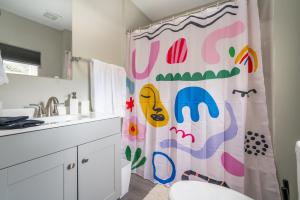 a bathroom with a shower curtain with a sink at Luxury 1 bed APT near Five Point. Pets welcome! in Columbia +6 photos