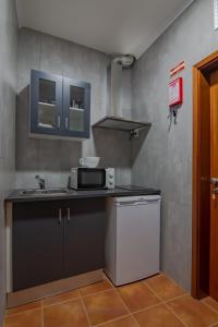 una pequeña cocina con fregadero y microondas en Casa da T´Idalete, en Ourique