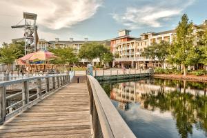 a wooden walkway next to a river with buildings at Elation #5316 in Destin