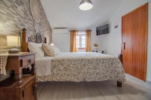 1 dormitorio con 1 cama grande y vestidor de madera en Casa da T´Idalete, en Ourique