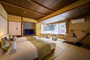 a bedroom with a large bed and a large window at Onogawa Onsen Kajikaso in Yonezawa