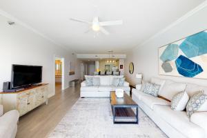 a living room with white furniture and a flat screen tv at Navarre Beach Regency 805 in Navarre