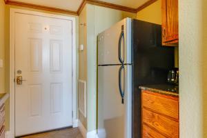 a kitchen with a refrigerator next to a door at Pirates Bay A410 in Fort Walton Beach