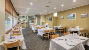 a restaurant with tables and chairs with white table linen at Cootamundra Gardens Motel in Cootamundra