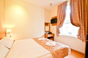 a bedroom with a bed and a window at Kings Cross Inn Hotel in London