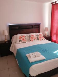 een slaapkamer met een bed met twee handdoeken erop bij Nuevo Amanecer in Santiago