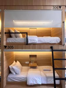 a room with three bunk beds in it at Sleep Studio Hotel City Center Surabaya in Tembok