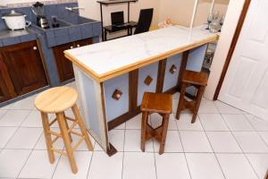 a kitchen with a counter and some wooden stools at Apartamento Daly 3 in Guápiles