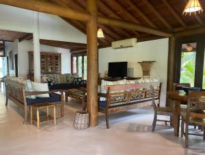 uma sala de estar com mesa e cadeiras em Villa Oberoi pé na areia alto luxo em Santo André