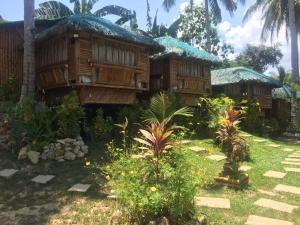 a wooden house with a garden in front of it at Coco Garden Villas in El Nido