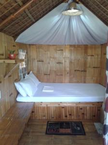 a bed in a wooden room with a ceiling at Coco Garden Villas in El Nido