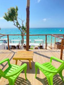 2 sillas verdes y una mesa de madera en la playa en SUNSET BEACH, en Playa Blanca