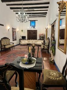 a living room with a table and chairs at Hotel Boutique Casa de Hacienda Su Merced in Puembo