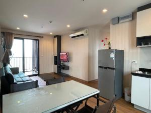 a kitchen and living room with a table and a refrigerator at The Base Pattaya in Pattaya Central