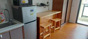 a kitchen with a refrigerator and a counter with stools at Mega tower 3 staycation in Baguio
