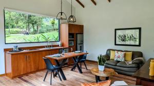 蒙特韋爾德哥斯達黎加的住宿－UNFORGETTABLE PLACE,Monteverde Casa Mia near main attractions and town，厨房以及带桌子和沙发的客厅。