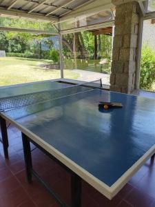 una mesa de ping pong con una raqueta encima en Los Oleandros - casa privada en Nono