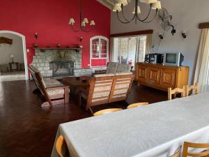 sala de estar con chimenea, mesa y sillas en Los Oleandros - casa privada en Nono