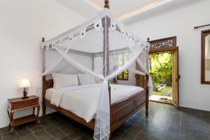 sypialnia z łóżkiem z baldachimem w pokoju w obiekcie Bijia Villa 3BR w Private Pool - Peaceful Quiet Luxury Villa - Near Monkey Forest w mieście Ubud