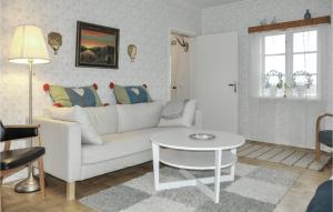 een woonkamer met een witte bank en een tafel bij 2 Bedroom Amazing Home In Charlottenberg in Charlottenberg