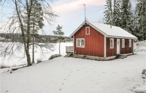 Cabaña roja con nieve en el suelo en Amazing Home In Kristinehamn With Wifi, en Rådetorp